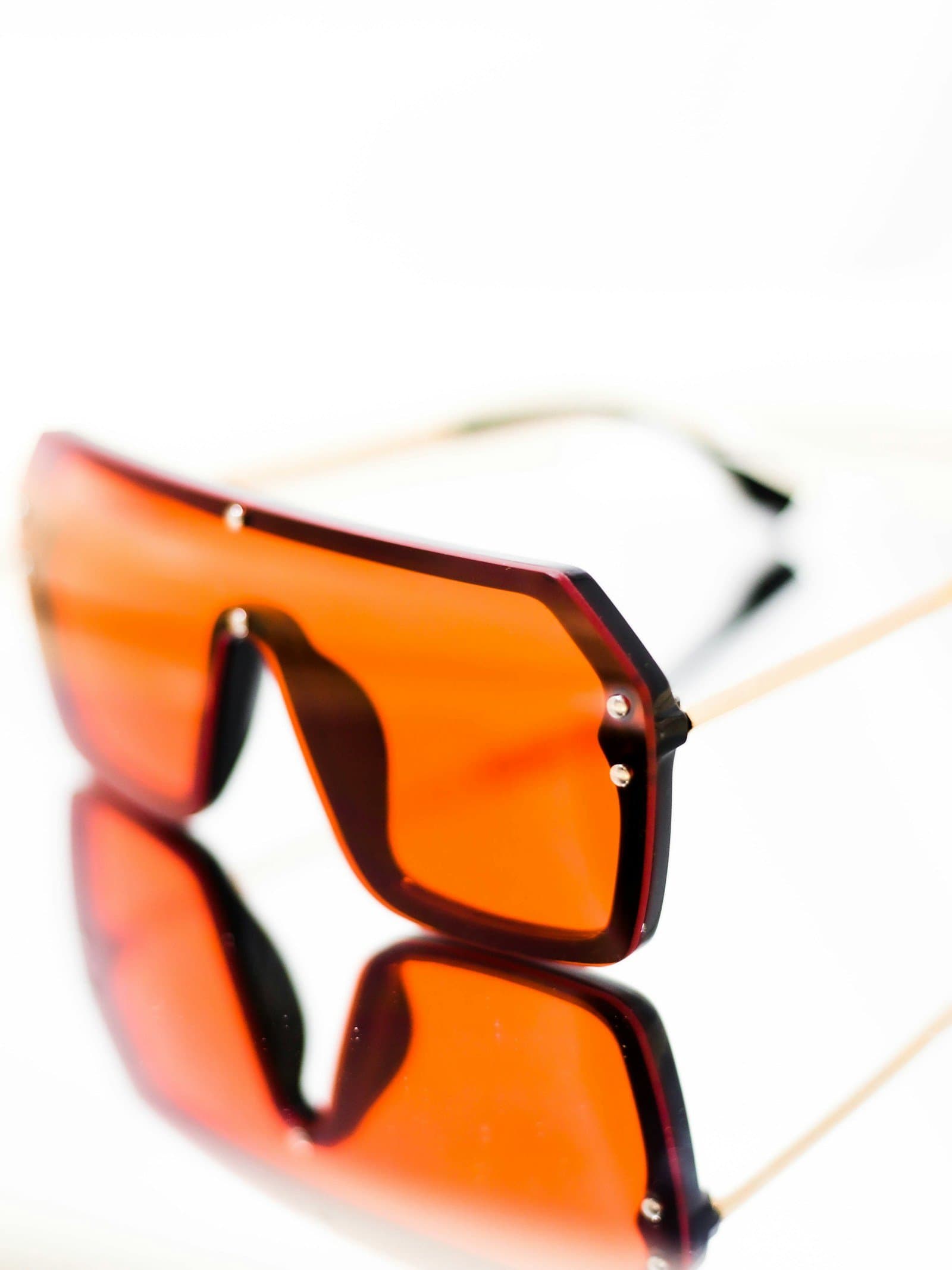 Jamr shield sunglasses with a single orange lens in a copper rim