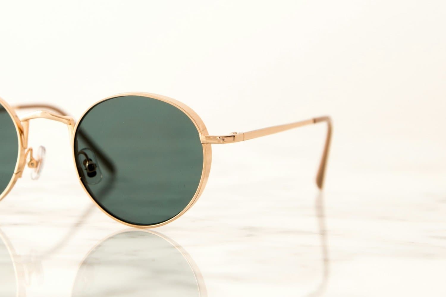 Close-up of the Dahab gold-tone rim, hinge and green lens